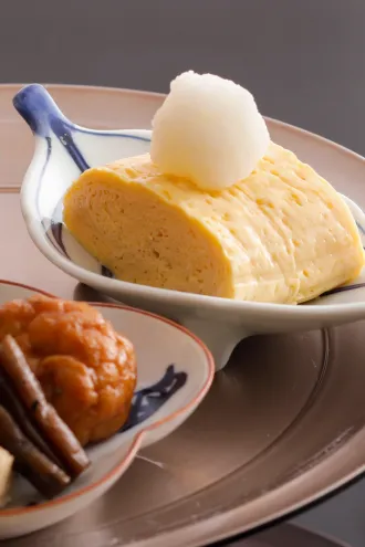 大根おろしが添えられた、ふんわりと焼き上げられた厚焼きだし巻き玉子。