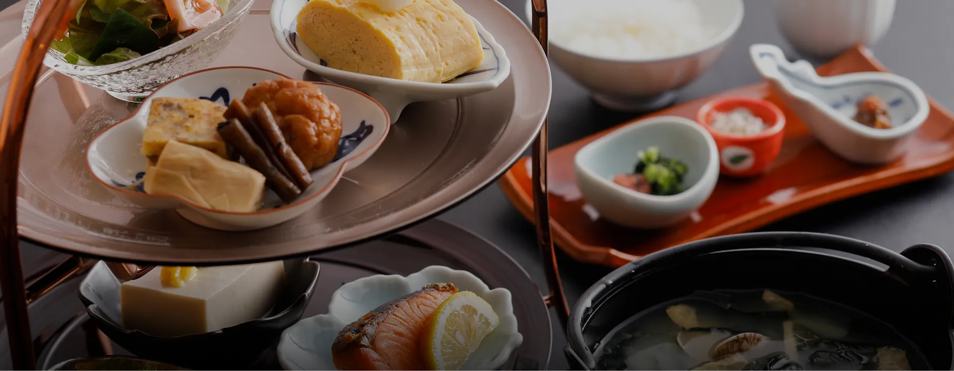 スタンド仕立ての器に小鉢やだし巻き玉子が盛られた、彩り豊かな和朝食。