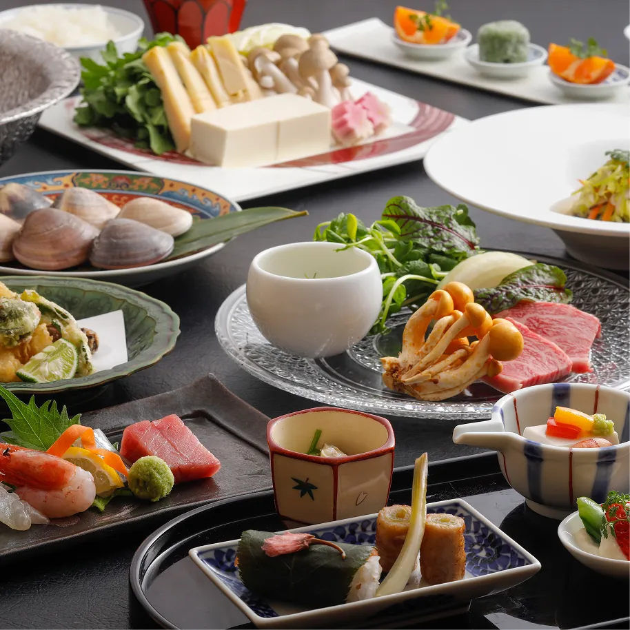 山海の旬食材が卓上に並ぶ、華やかなコース料理の全景。