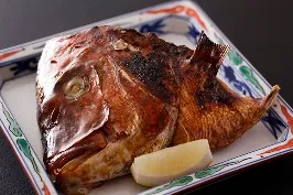 角皿に盛り付けられた、香ばしく焼き上げられた鯛のかぶと焼き。