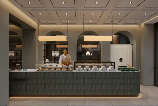 Sweets shop interior with an elegant service counter and architectural arches beneath warm lighting.
